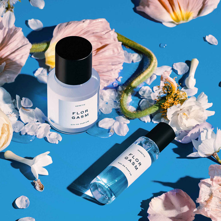 Florgasm Eau de Parfum 30ml und 15 ml mit Blüten auf blauem Hintergrund - Heretic Parfum